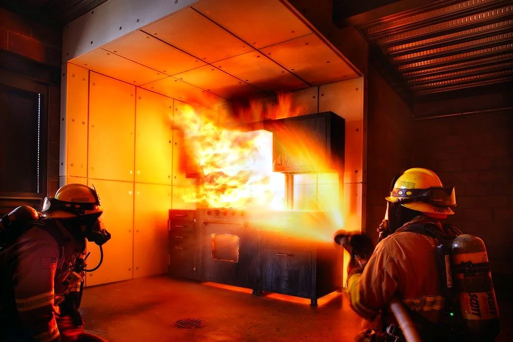 Firefighters conducting live fire suppression training inside a custom NFPA 1403-compliant burn building — Stump MFG
