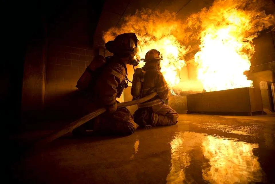 Two firefighters observing fire development from low position inside a custom flashover chamber — Stump Construction and Manufacturing
